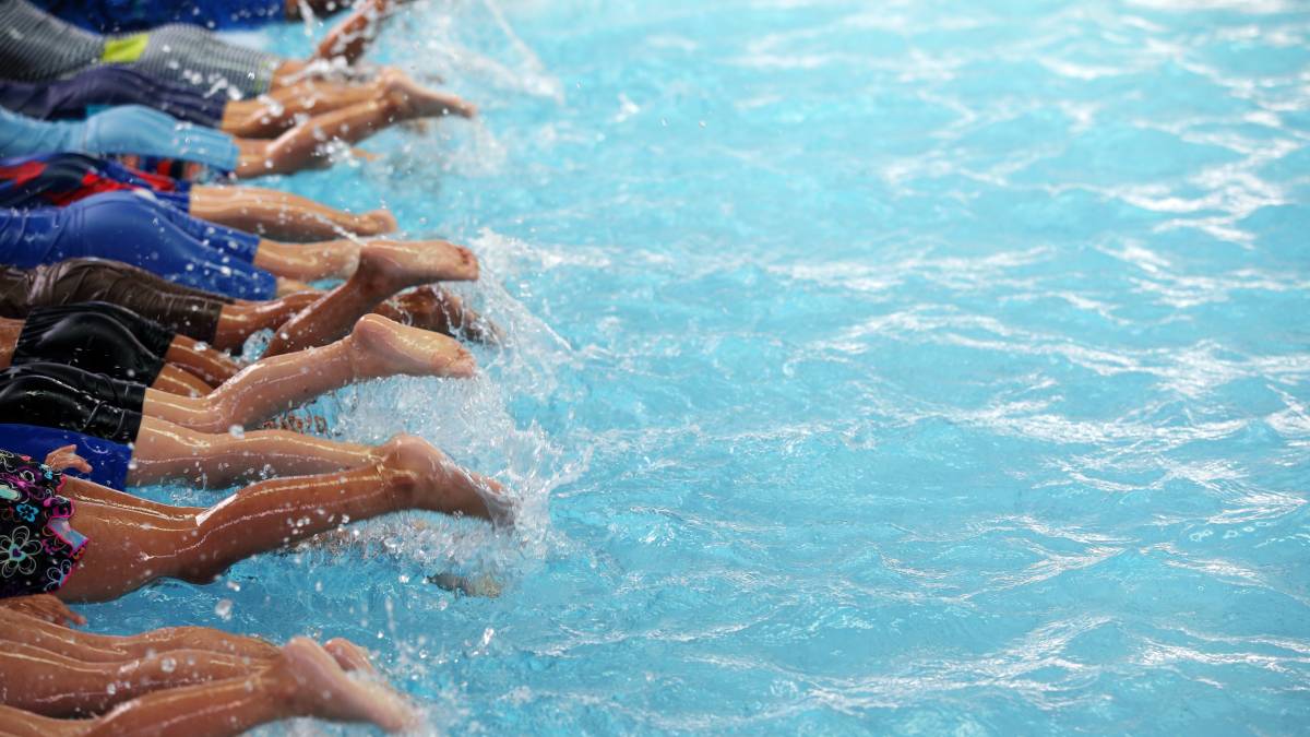 legs of children swimming, close shot, showing the concept of affordable swimming clubs