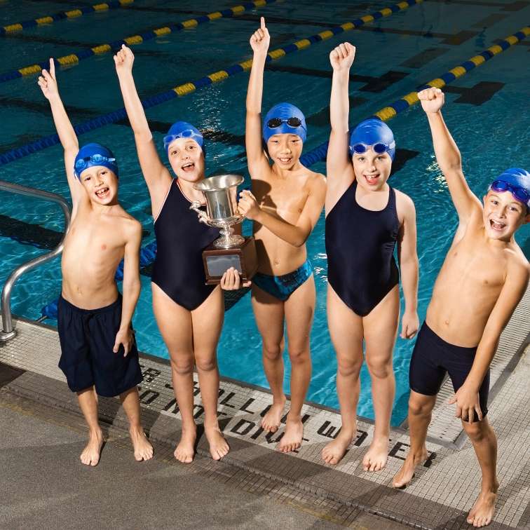 swimming club team holding their trophy as a way of staying motivated at a swimming club 