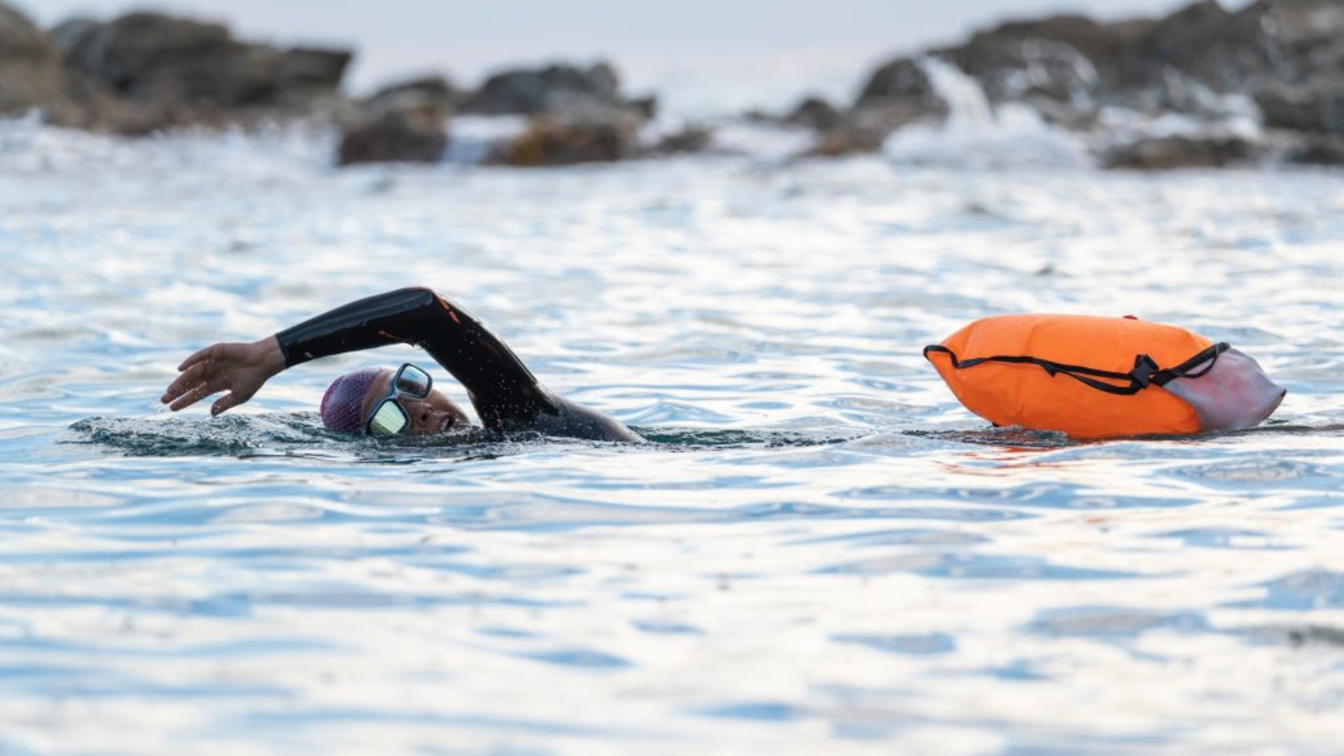 A person in a swimming pool swimming showing Tips for Open Water Swimming Safety.