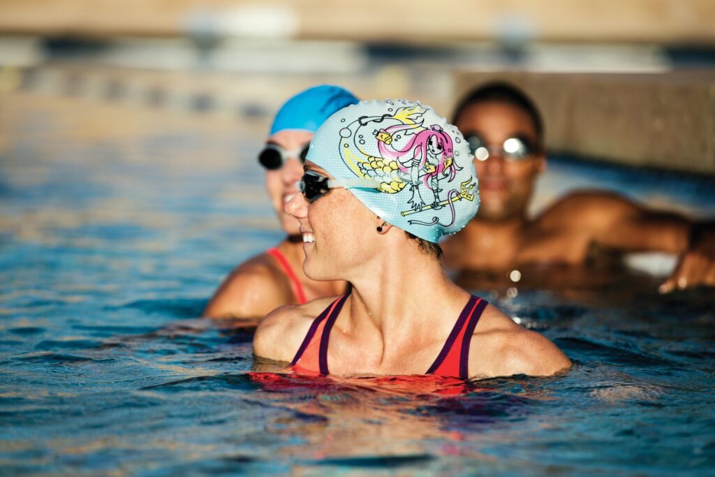 two women wearing swimming caps 